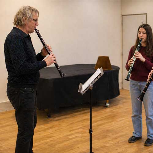 Cours de musique avec professeur et élèves jouant de la clarinette en répétition