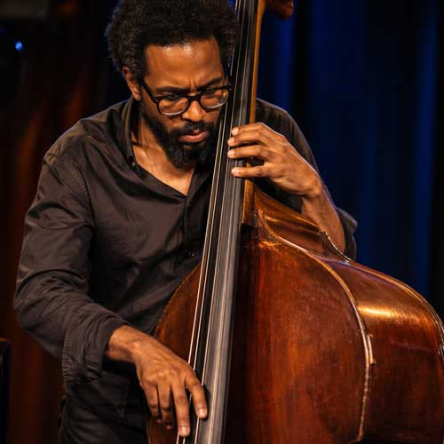 Musicien de jazz jouant de la contrebasse sur scène avec concentration