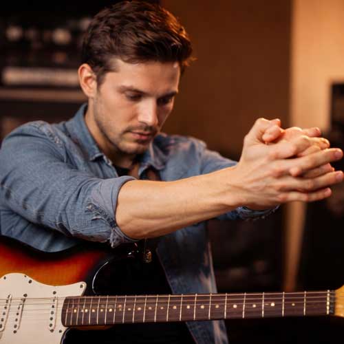 Musiciens réalisant des exercices d’échauffement des mains, poignets et épaules avant la pratique instrumentale