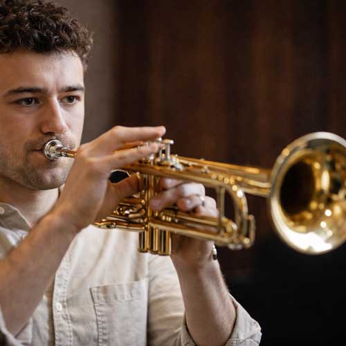 Photo d'un jeune trompettiste pour illustrer la conférence : Les pathologies liées à la pratique instrumentale chez les instrumentistes à vent
